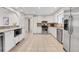 Modern kitchen with stone countertops, stainless steel appliances, and sleek white cabinets at 13577 W Alaska Dr, Lakewood, CO 80228