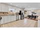 White cabinet kitchen adjacent to dining room with stainless steel appliances and tile flooring at 13577 W Alaska Dr, Lakewood, CO 80228