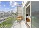 Balcony with seating area and view into bright bedroom with ski wall art and bed at 2550 Lawrence St # Rb306, Denver, CO 80205