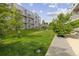 Lush green lawn with modern apartment buildings and a swing set in a vibrant community setting at 2550 Lawrence St # Rb306, Denver, CO 80205