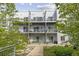 Modern condo building with multiple balconies and lush landscaping in a desirable community setting at 2550 Lawrence St # Rb306, Denver, CO 80205