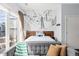 Main bedroom with ski lift wall art, hardwood floors and couch overlooking private balcony at 2550 Lawrence St # Rb306, Denver, CO 80205