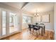 Elegant dining room with modern lighting, a neutral color palette, and a view of the lush backyard at 3597 S Joplin St, Aurora, CO 80013