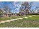 Suburban home with a well-manicured front yard, mature trees, and a walking path at 3597 S Joplin St, Aurora, CO 80013
