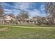 Suburban home featuring a well-manicured front yard with mature trees and a fence at 3597 S Joplin St, Aurora, CO 80013