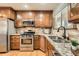 Well-equipped kitchen with stainless steel appliances, granite counters, and custom wood cabinetry, ideal for cooking at 3597 S Joplin St, Aurora, CO 80013