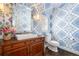 Stylish powder room featuring unique wallpaper, a vintage vanity, and modern fixtures at 6375 E Tufts Ave, Englewood, CO 80111