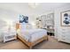 Bright bedroom with a woven bed frame, matching nightstands, and a built-in bookcase at 6375 E Tufts Ave, Englewood, CO 80111