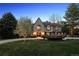 A beautiful two-story home features a stone facade, mature trees, and a well-manicured front yard at 6375 E Tufts Ave, Englewood, CO 80111
