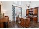 Home office with custom wood desk, built-in shelves, and ample natural light from the shuttered windows at 6375 E Tufts Ave, Englewood, CO 80111