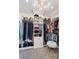 Custom walk-in closet with ample storage, shelving and zebra print carpet, illuminated by a modern chandelier at 6375 E Tufts Ave, Englewood, CO 80111