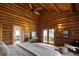 Spacious log cabin bedroom with a ceiling fan and access to a balcony with a beautiful view at 29095 Summit Ranch Dr, Golden, CO 80401