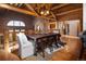 Rustic dining room with wooden table, chairs, and wood beamed ceiling in a log home at 29095 Summit Ranch Dr, Golden, CO 80401