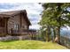 Charming log cabin with a wraparound deck and manicured lawn, set against a beautiful mountain backdrop at 29095 Summit Ranch Dr, Golden, CO 80401