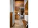 Hallway with travertine flooring, log cabin walls, and a view to the bathroom and bedroom at 29095 Summit Ranch Dr, Golden, CO 80401