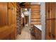 Rustic log-cabin style hallway with wood walls and tile flooring at 29095 Summit Ranch Dr, Golden, CO 80401