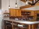 Kitchen featuring a granite countertop bar with seating, wooden cabinetry, and brick backsplash at 29095 Summit Ranch Dr, Golden, CO 80401