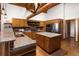 Rustic kitchen featuring wood cabinetry, granite countertops, brick backsplash, and center island at 29095 Summit Ranch Dr, Golden, CO 80401