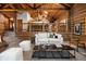 Open living room featuring log cabin walls, stone fireplace, and comfortable seating at 29095 Summit Ranch Dr, Golden, CO 80401