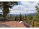Picturesque mountain vista from the property, framed by lush trees and a decorative mining cart at 29095 Summit Ranch Dr, Golden, CO 80401