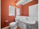 Bathroom with white pedestal sink, toilet, tile trim, and large mirror at 1635 N Franklin St, Denver, CO 80218