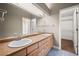 Bathroom featuring double sinks, a large mirror, and access to a walk-in closet at 1635 N Franklin St, Denver, CO 80218
