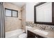 Bathroom features a shower and tub with modern fixtures, granite counters, tile flooring, and stylish vanity at 1940 E 95Th Ave, Thornton, CO 80229