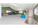 Expansive bonus room featuring a cozy blue sofa and ample space for play or relaxation at 1940 E 95Th Ave, Thornton, CO 80229