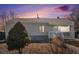 Charming single-story home with neutral siding, stone accents, and a cozy front porch under a beautiful sunset at 1940 E 95Th Ave, Thornton, CO 80229