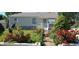 Well-maintained home featuring vibrant red roses and lush green landscaping along the walkway and in the yard at 1940 E 95Th Ave, Thornton, CO 80229