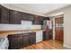 Functional kitchen features dark cabinets, hardwood floors, and essential appliances, including a stainless steel refrigerator at 1940 E 95Th Ave, Thornton, CO 80229