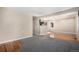 Spacious living area with a mix of cozy gray carpet and warm hardwood flooring, freshly painted and well-lit at 1940 E 95Th Ave, Thornton, CO 80229