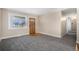 Inviting living room features plush gray carpet, fresh neutral paint, and a charming wood front door at 1940 E 95Th Ave, Thornton, CO 80229