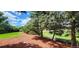 Landscaped backyard with lush grass, mature trees, and a charming garden area at 4475 S Routt St, Littleton, CO 80127