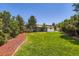 Lush backyard with manicured lawn, mature trees and an inviting patio perfect for entertaining at 4475 S Routt St, Littleton, CO 80127