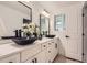 Stylish bathroom with double sink vanity, white cabinets and decorative black hardware at 4475 S Routt St, Littleton, CO 80127