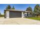 Exterior featuring a two-car garage, a well-manicured lawn, and a welcoming front porch at 4475 S Routt St, Littleton, CO 80127