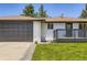 A single-story home shows an attached garage, small deck, and manicured lawn at 4475 S Routt St, Littleton, CO 80127