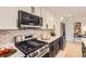 Modern kitchen showcasing stainless steel appliances, white cabinets, and subway tile backsplash at 4475 S Routt St, Littleton, CO 80127
