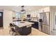 Bright kitchen with a central island, stainless steel refrigerator, and modern light fixture at 4475 S Routt St, Littleton, CO 80127
