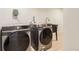 Modern laundry room showcasing Samsung front-load washer and dryer with a utility sink at 4475 S Routt St, Littleton, CO 80127