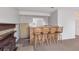 Basement bar area featuring wood countertop, storage, wood stools, and a small refrigerator at 1005 S Lewiston Way, Aurora, CO 80017