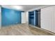 Basement rec room with vinyl flooring, closet, and bright blue accent wall at 1005 S Lewiston Way, Aurora, CO 80017
