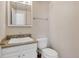 Well-lit half bathroom with a vanity, sink, framed mirror, and a toilet, providing convenience at 1005 S Lewiston Way, Aurora, CO 80017