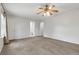Bright primary bedroom featuring neutral carpet, ceiling fan, and ensuite bathroom with ample closet space at 1005 S Lewiston Way, Aurora, CO 80017