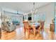 Bright open dining and living area featuring hardwood floors, plantation shutters, and modern lighting at 7193 S Versailles Way, Aurora, CO 80016