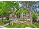 Charming home exterior with stone accents, manicured lawn, mature trees, and inviting front porch at 7193 S Versailles Way, Aurora, CO 80016