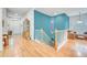 Elegant hallway features hardwood floors, a staircase, and vibrant blue accent walls, adding a touch of sophistication at 7193 S Versailles Way, Aurora, CO 80016