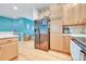 Functional kitchen featuring wood cabinets and stainless steel refrigerator at 7193 S Versailles Way, Aurora, CO 80016