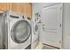 Convenient laundry room featuring modern washer and dryer and ample cabinet storage at 7193 S Versailles Way, Aurora, CO 80016